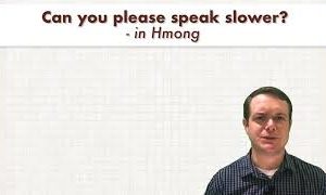 Text reading “Can you please speak slower? - in Hmong” above a man standing against a plain light background.