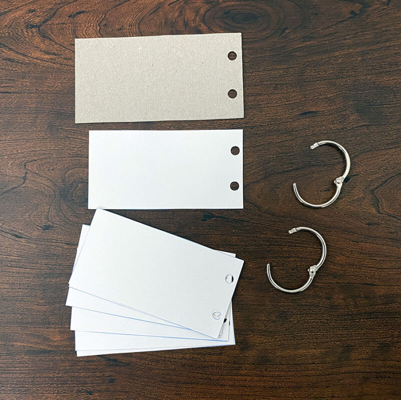 A photo of the flash cards that are cut out and hole punched with the rings nearby.